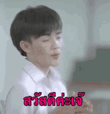 a young boy in a white shirt is making a funny face in a classroom with a foreign language .