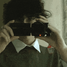 a person taking a picture with a camera that says gh