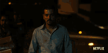 a man in a blue shirt with a netflix logo on the bottom right