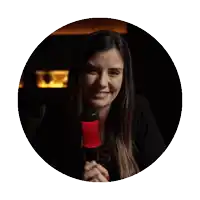 a woman in a black shirt stands in front of a red microphone with the letter t on it