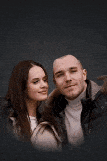 a man and a woman are posing for a picture with a fireball in the background