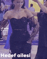 a woman in a black dress and long gloves is dancing with other women .