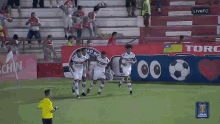 a group of soccer players are running on a field in front of a banner that says torc