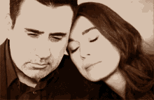 a man and a woman with their eyes closed rest their head on each other 's shoulders
