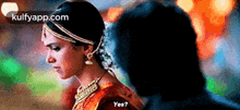 a woman in a sari is standing next to a man and says yes