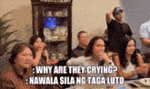 a group of people are sitting around a table with a caption that says " why are they crying "