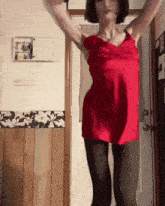 a woman in a red dress dancing in front of a door