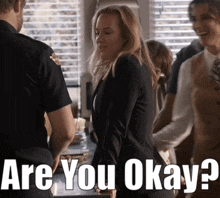 a woman standing next to a police officer with the words " are you okay " written below her