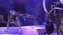 a group of people are dancing on a stage in front of a crowd .