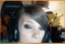 a close up of a woman 's face with a pikachu in the background
