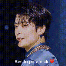 a close up of a man 's face with a microphone and the words besito para nick written on it .