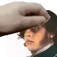 a hand is touching a man 's forehead with a hat on .
