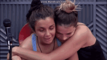 two women hugging each other in front of a microphone with the website www.bandicam.com visible