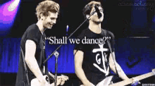 two men playing guitars and singing into microphones with the words " shall we dance "