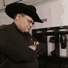 a man wearing a cowboy hat and glasses is looking down