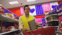 a man in a yellow vest is pushing a shopping cart in a store .