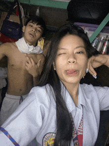 a shirtless man and a girl pose for a picture and the girl has a lanyard that says ' filipino ' on it