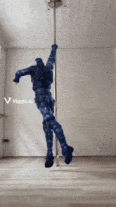 a statue of a man is hanging from a pole with the letters viggle.ai above it
