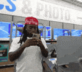 a man wearing a red hat that says glory pieces is looking at his phone