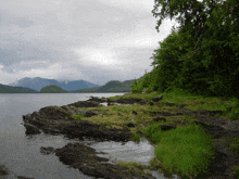 a lake with mountains in the background and a rocky shoreline