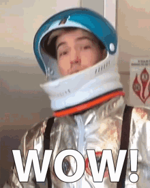 a man wearing a helmet and a space suit with the word wow on it
