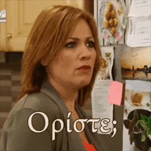 a woman is standing in front of a refrigerator with sticky notes on it and the word opistei on it
