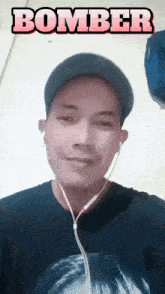 a man wearing ear buds and a hat has the word bomber above his head
