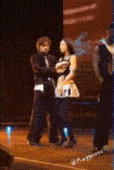 a man and a woman are dancing on a stage with the number 21 visible