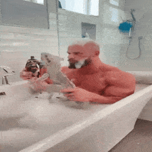 a shirtless man is taking a bath in a tub