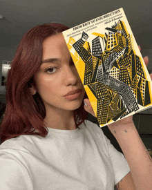 a woman with red hair holds a book titled from riot to insurrection