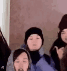 a group of people are standing next to each other and one of them is wearing a hat .