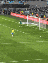 a soccer player in a yellow jersey kicks a ball into the goal