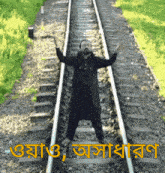 a man is standing on train tracks with his arms up