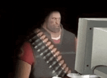 a man with a beard is sitting in front of a computer screen .