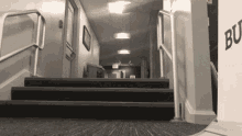 a black and white photo of a hallway with stairs and a sign that says bo