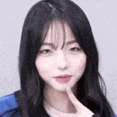 a close up of a young woman with long black hair and bangs making a funny face .