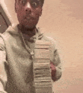 a man is holding a stack of money in his hand and taking a selfie .