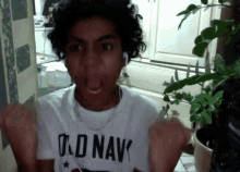 a young man wearing a t-shirt that says u.s. navy is making a funny face