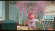 a girl with red hair is dancing in a bedroom with regal written on the bottom right
