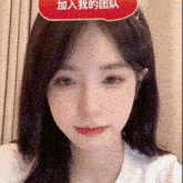 a close up of a woman 's face with a red speech bubble on her forehead .