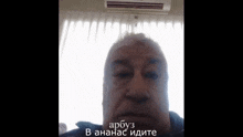 a man is taking a selfie in front of a window with a air conditioner on the ceiling .