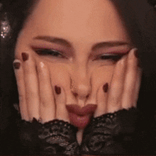 a close up of a woman making a face with her hands on her face .
