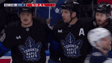 three toronto maple leafs hockey players are standing in the stands