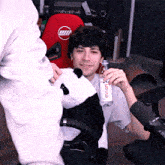 a man holding a bottle of evian water