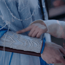 a close up of a person 's arm with a blue bracelet on