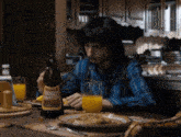 a man sits at a table with a bottle of bomer worths