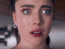 a close up of a woman 's face with a star earring on her ear