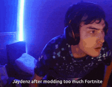 a man wearing headphones says jaydenz after modding too much fortnite in a dark room