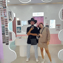 a man and a woman are posing for a picture in front of a sign that says ' ee dash '