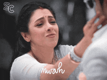 a woman is crying while looking at herself in a mirror with the words " mwah " on the bottom
